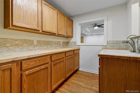 a kitchen with stainless steel appliances granite countertop a sink and cabinets with wooden floor