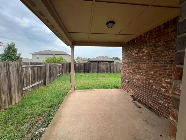 a view of a backyard with wooden fence