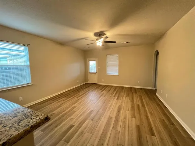 a view of a room with wooden floor and ceiling fan