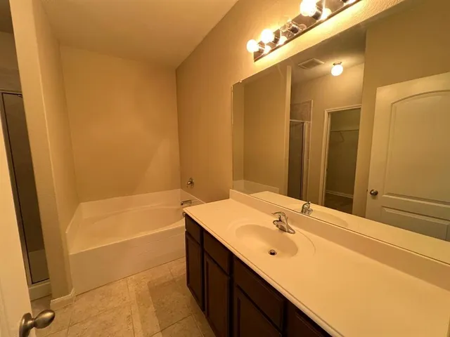 a bathroom with a tub sink and a mirror