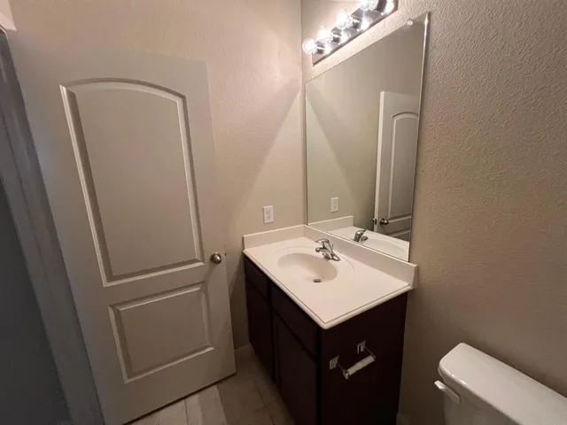 a bathroom with a sink a toilet and mirror