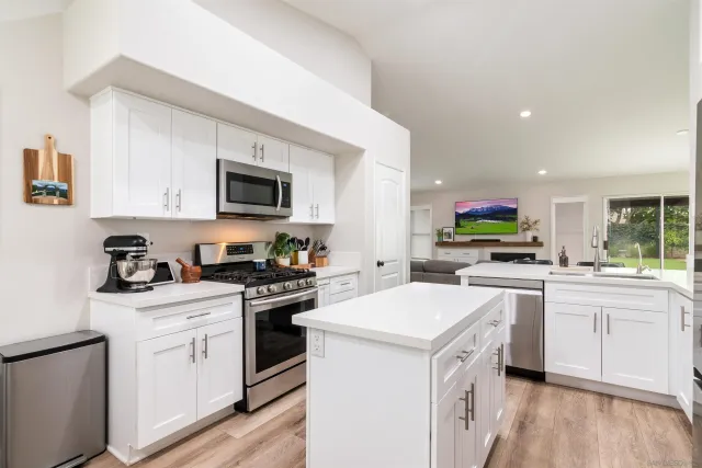 a kitchen with white cabinets and white appliances