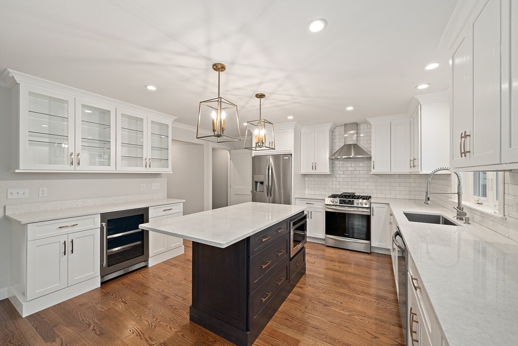 15 Lakeview Avenue Waltham, MA 02451 - Photo 11 of 34 a large kitchen with stainless steel appliances granite countertop a stove top oven a refrigerator a sink and dishwasher with wooden floor