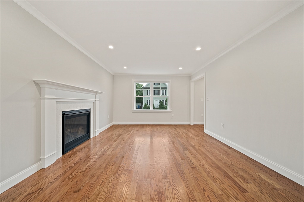 15 Lakeview Avenue Waltham, MA 02451 - Photo 8 of 34 an empty room with wooden floor fireplace and windows