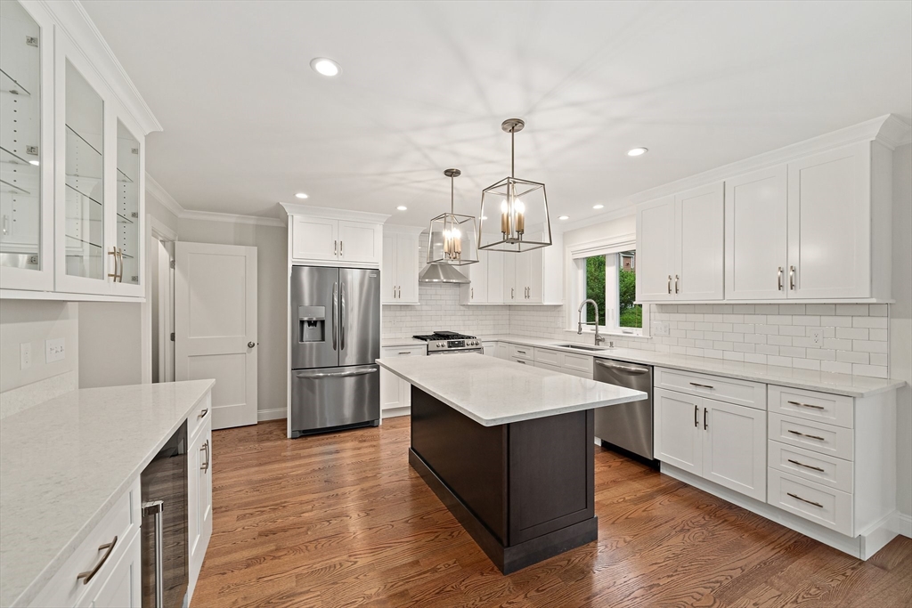 15 Lakeview Avenue Waltham, MA 02451 - Photo 10 of 34 a kitchen with a refrigerator a sink dishwasher a stove and white cabinets with wooden floor
