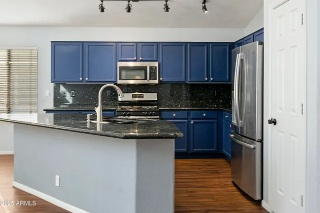 a kitchen with wooden cabinets and stainless steel appliances