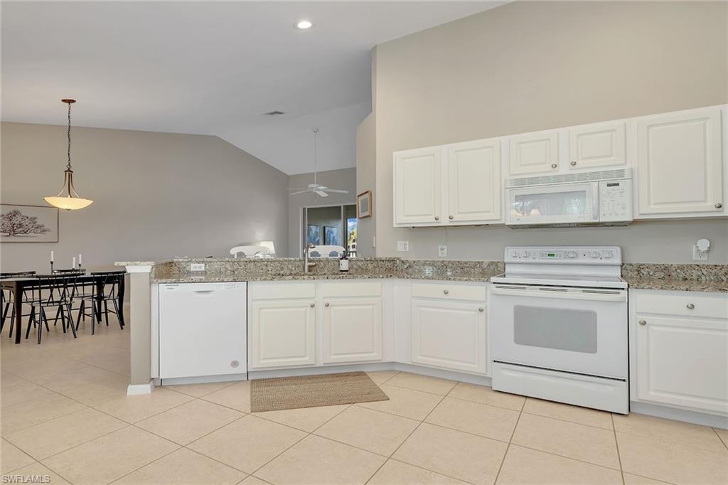9189 Spring Run Boulevard, Unit 1908 Estero, FL 34135 - Photo 5 of 33 a kitchen with cabinets and white appliances