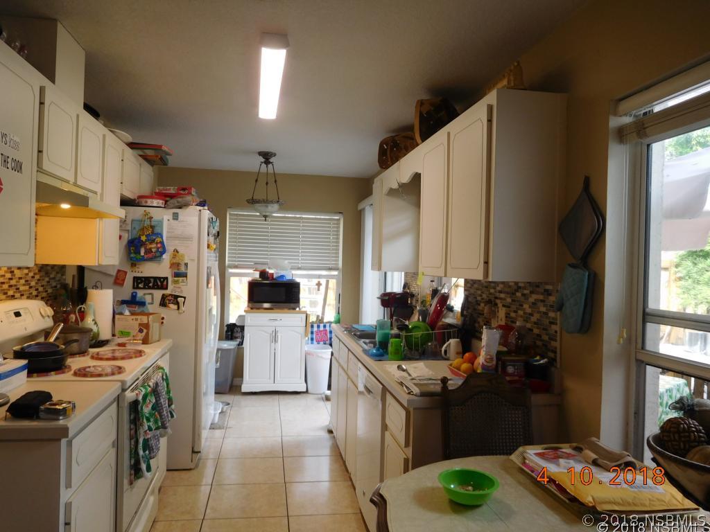 113 Boston Road Edgewater, FL 32141 - Photo 3 of 6 a kitchen with stainless steel appliances kitchen island granite countertop a stove refrigerator and cabinets