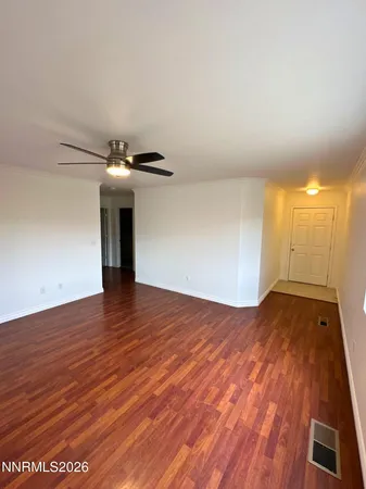 a view of empty room with wooden floor