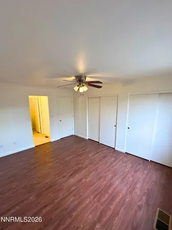 a view of empty room with wooden floor