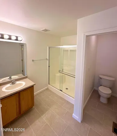 a bathroom with a granite countertop sink a toilet and a shower