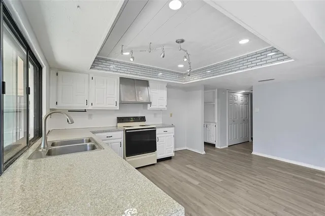 a large kitchen with stainless steel appliances granite countertop a lot of counter space and wooden floor