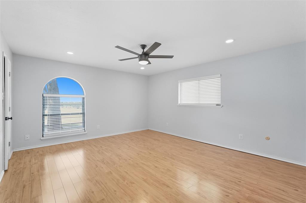 6108 Jennings Drive The Colony, TX 75056 - Photo 19 of 32 an empty room with windows and ceiling fan