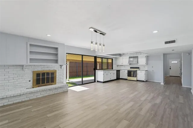 a view of an empty room with window and cabinet