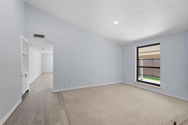 an empty room with windows and closet