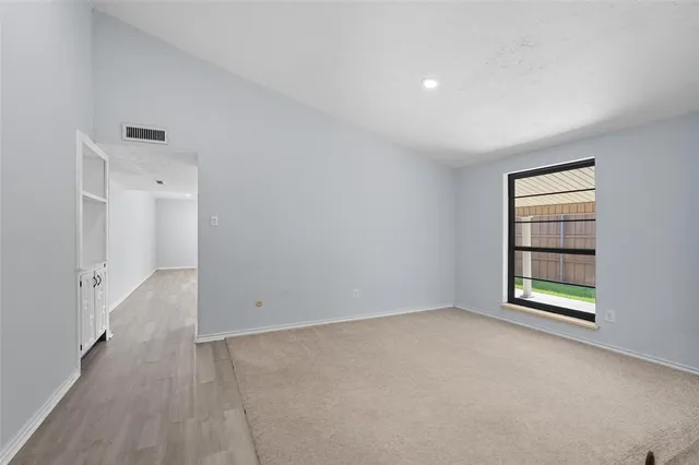 an empty room with windows and closet