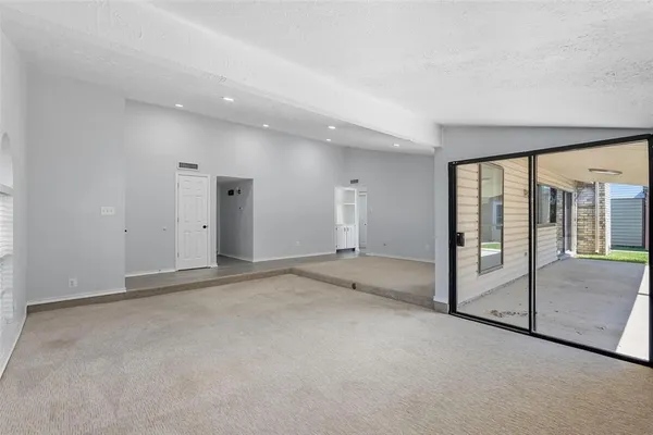 a view of an empty room with sliding glass door