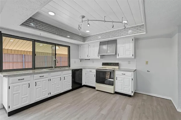 a kitchen with granite countertop a stove and a sink