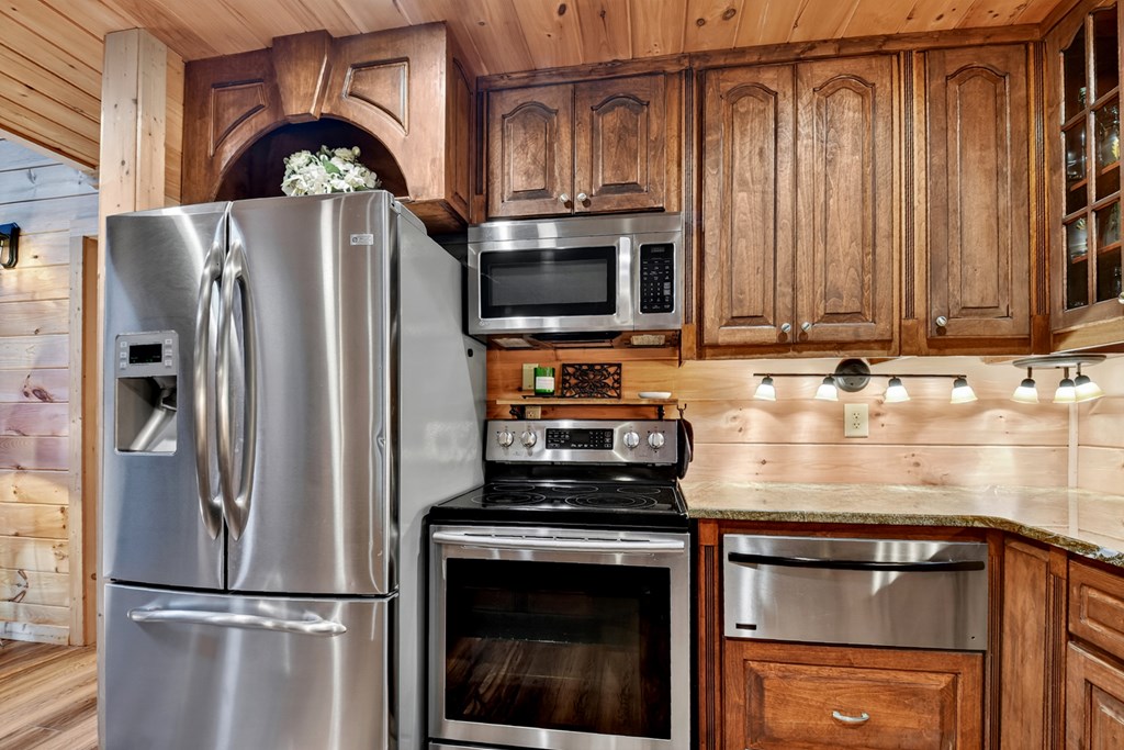 523 Long Branch Road Ranger, GA 30734 - Photo 32 of 56 a kitchen with stainless steel appliances granite countertop a refrigerator a stove and a sink with wooden floor