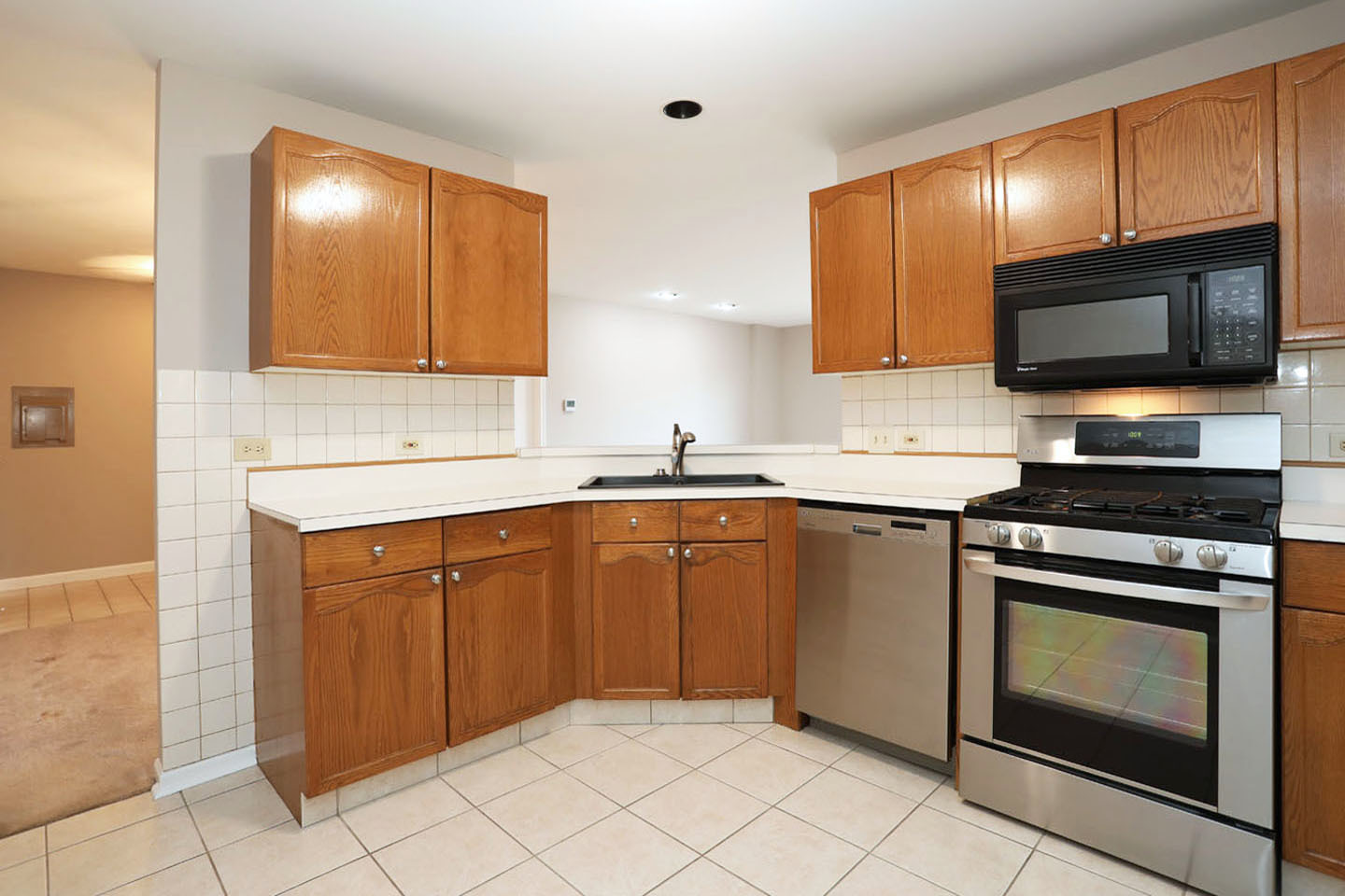 815 Leicester Road, Unit 108 Elk Grove Village, IL 60007 - Photo 11 of 34 a kitchen with stainless steel appliances granite countertop a sink stove and microwave