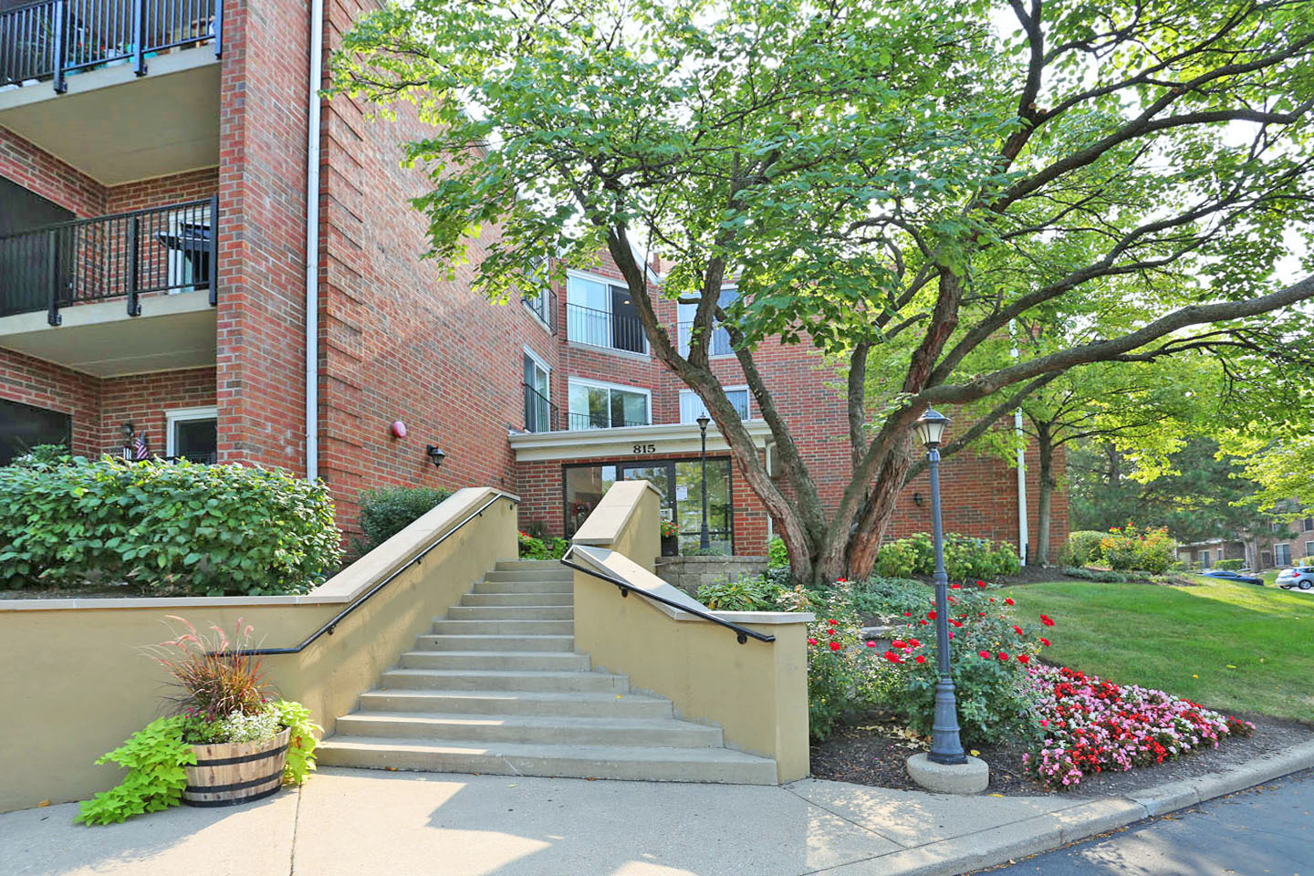 815 Leicester Road, Unit 108 Elk Grove Village, IL 60007 - Photo 3 of 34 a view of a house with a yard and potted plants