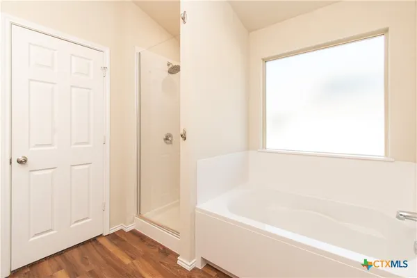 a white bath tub sitting next to a shower