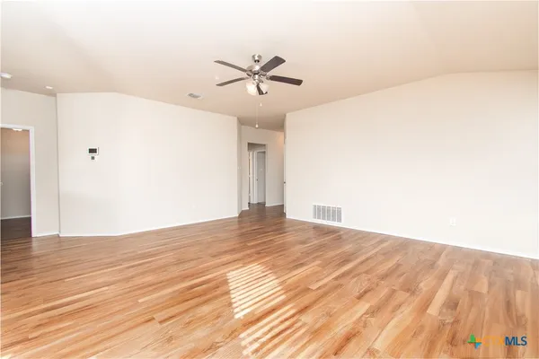 a view of a big room with wooden floor and windows in a room