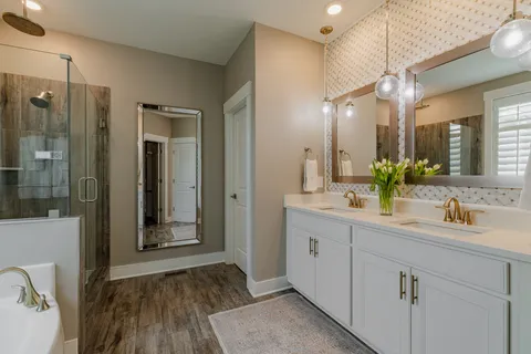 a bathroom with a double vanity sink mirror and shower