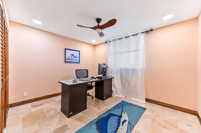 a view of a workspace with furniture and a window