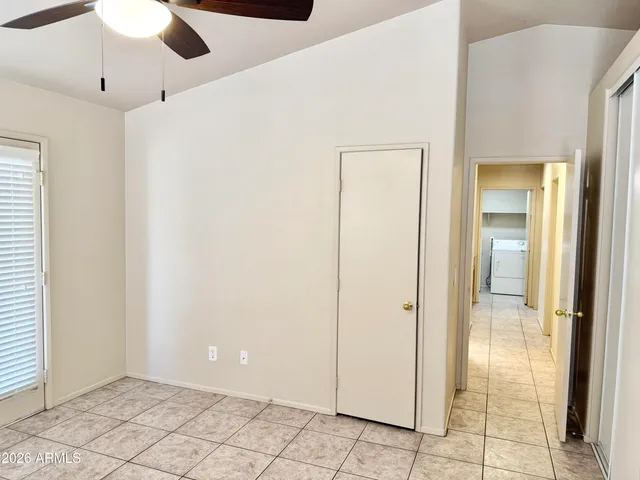a view of an empty room and window chandelier fan