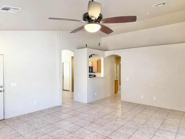 a view of a room with a chandelier fan and windows