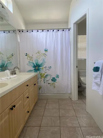a bathroom with a granite countertop sink a toilet and shower
