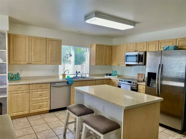 a kitchen with a sink a counter top space cabinets and stainless steel appliances