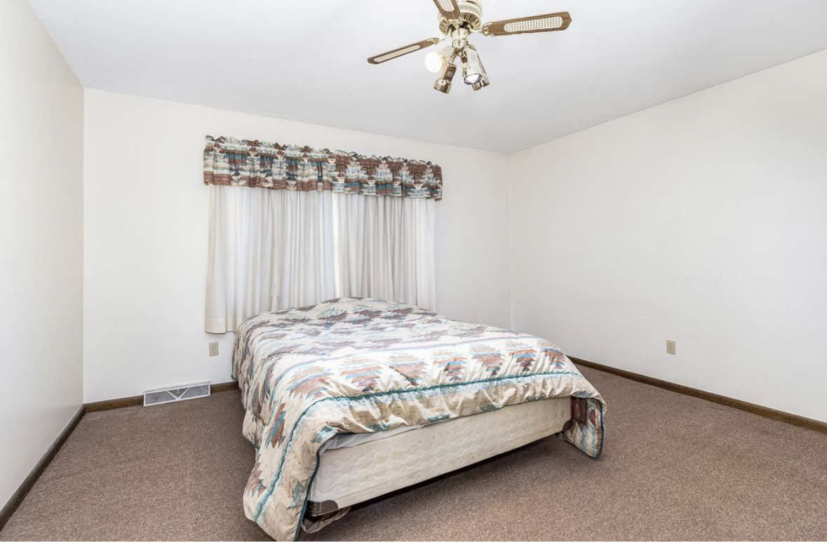 1943 Church Road Aurora, IL 60505 - Photo 9 of 31 a bedroom with a bed and a chandelier