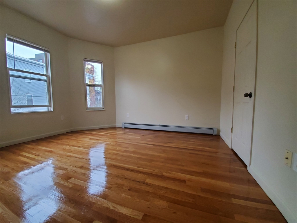 5 Coleman Street, Unit 2 Boston, MA 02125 - Photo 8 of 9 a view of an empty room with wooden floor and a window