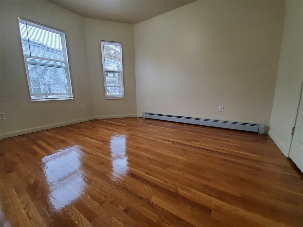 5 Coleman Street, Unit 2 Boston, MA 02125 - Photo 9 of 9 an empty room with wooden floor and windows