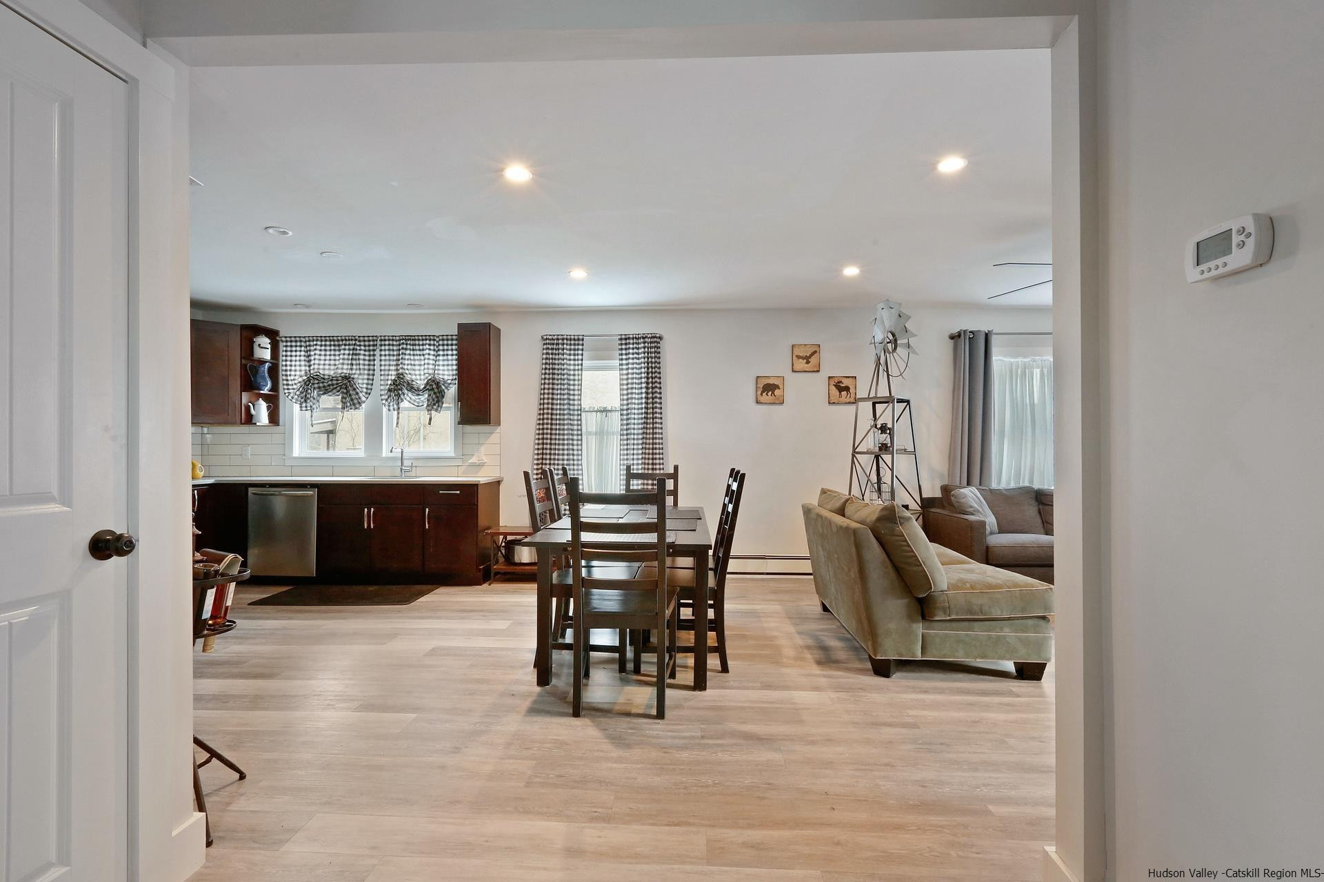 7732 Main Street Hunter, NY 12442 - Photo 5 of 25 a living room with furniture and a dining table with wooden floor