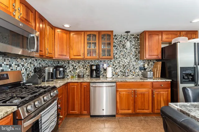 a kitchen with stainless steel appliances granite countertop a stove sink and cabinets