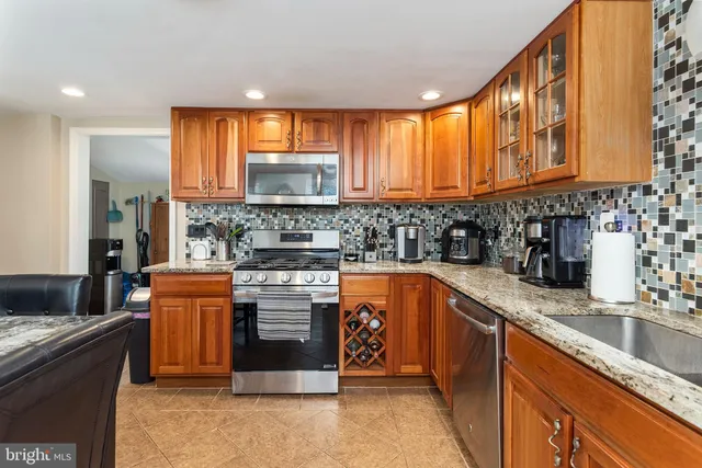 a kitchen with stainless steel appliances granite countertop a refrigerator and a sink