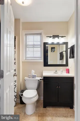 a bathroom with a toilet sink and mirror