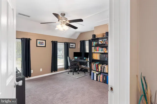 a backyard of a house with large trees and wooden fence