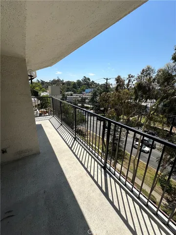 a view of balcony with wooden floor and fence