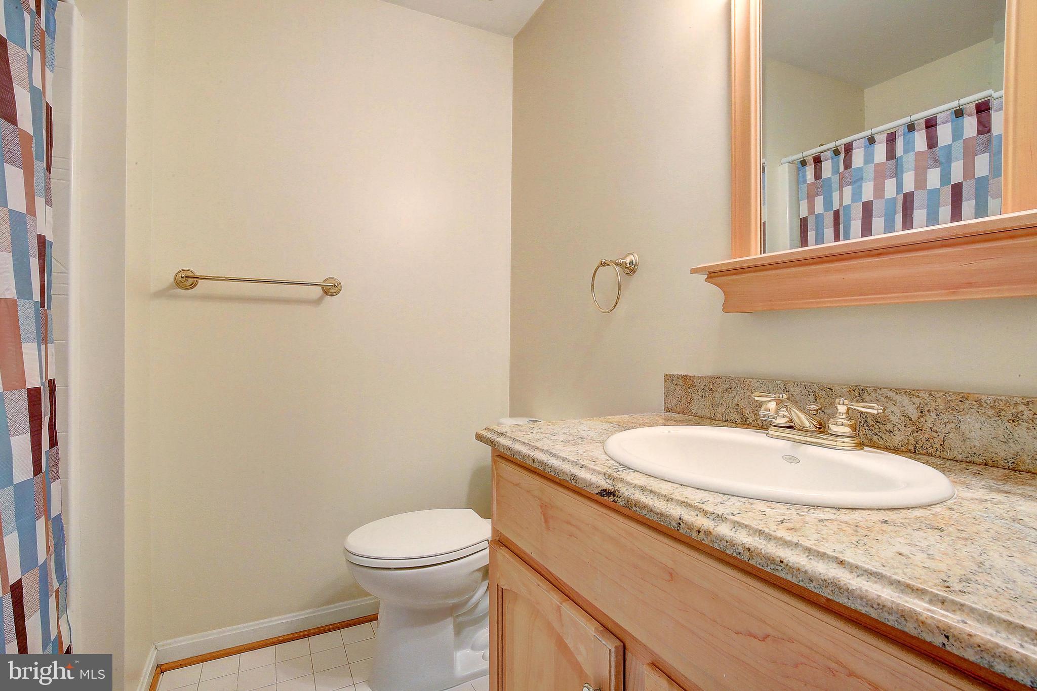 3300 Holland Cliffs Road Huntingtown, MD 20639 - Photo 67 of 93 a bathroom with a granite countertop sink toilet and a mirror