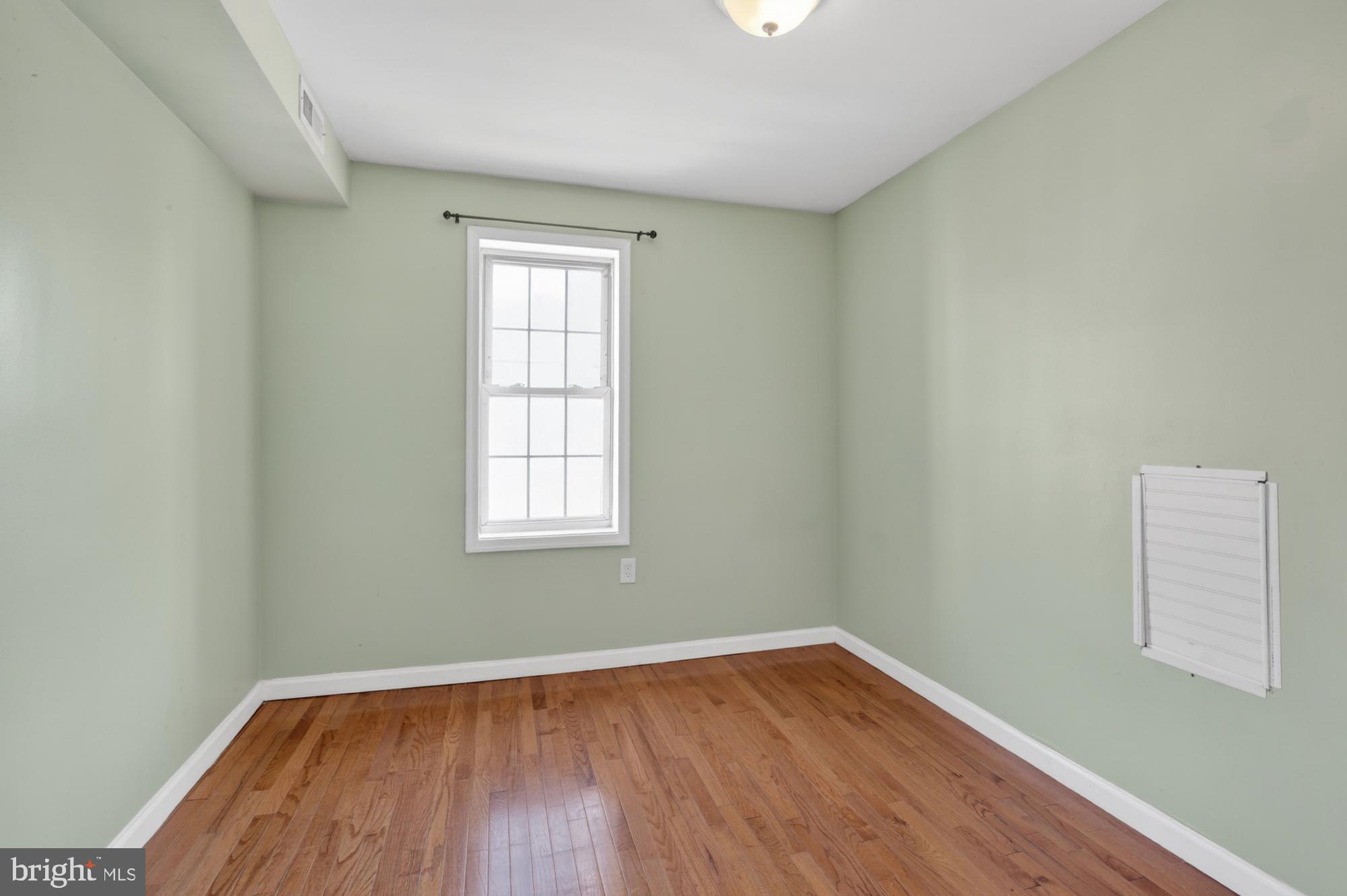 1400 South Chadwick Street, Unit 2 Philadelphia, PA 19146 - Photo 16 of 20 an empty room with wooden floor and windows