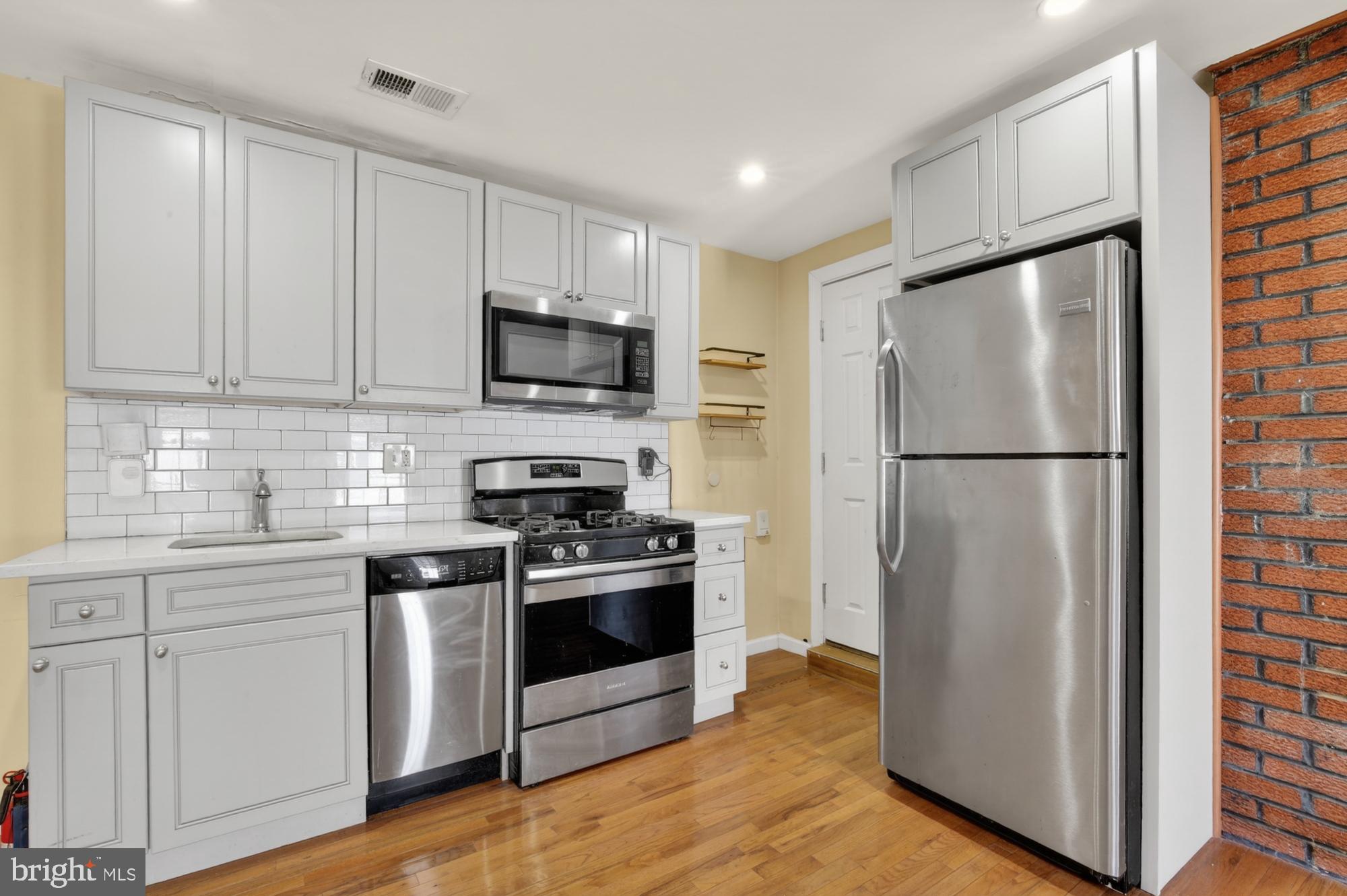 1400 South Chadwick Street, Unit 2 Philadelphia, PA 19146 - Photo 5 of 20 a kitchen with stainless steel appliances a refrigerator stove and microwave