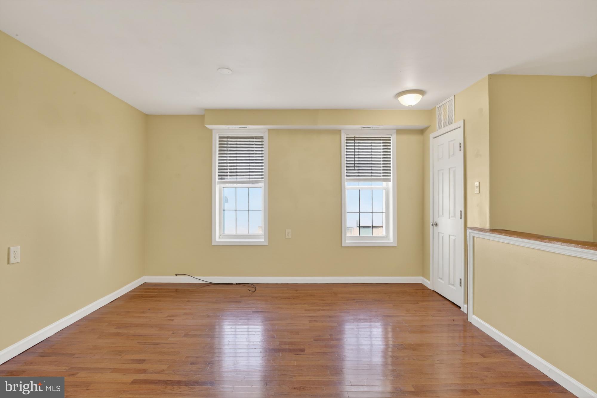 1400 South Chadwick Street, Unit 2 Philadelphia, PA 19146 - Photo 6 of 20 a view of an empty room with wooden floor and a window