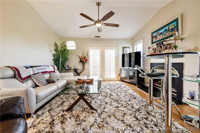 a living room with furniture a flat screen tv and a table