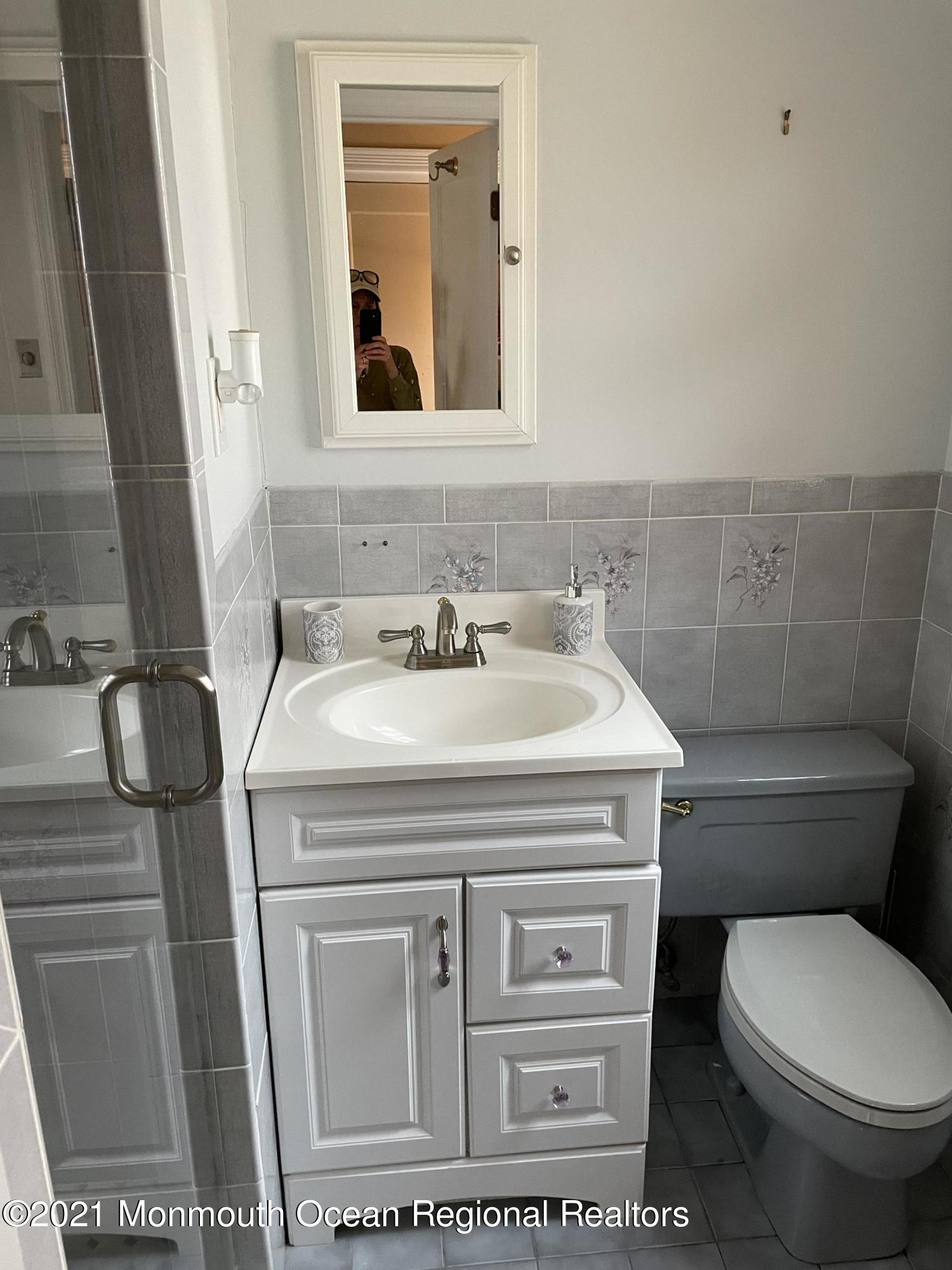 241 Cliftwood Road Oakhurst, NJ 07755 - Photo 11 of 27 a bathroom with a toilet sink and mirror