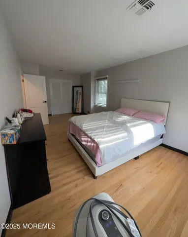 a spacious bedroom with a bed and dresser