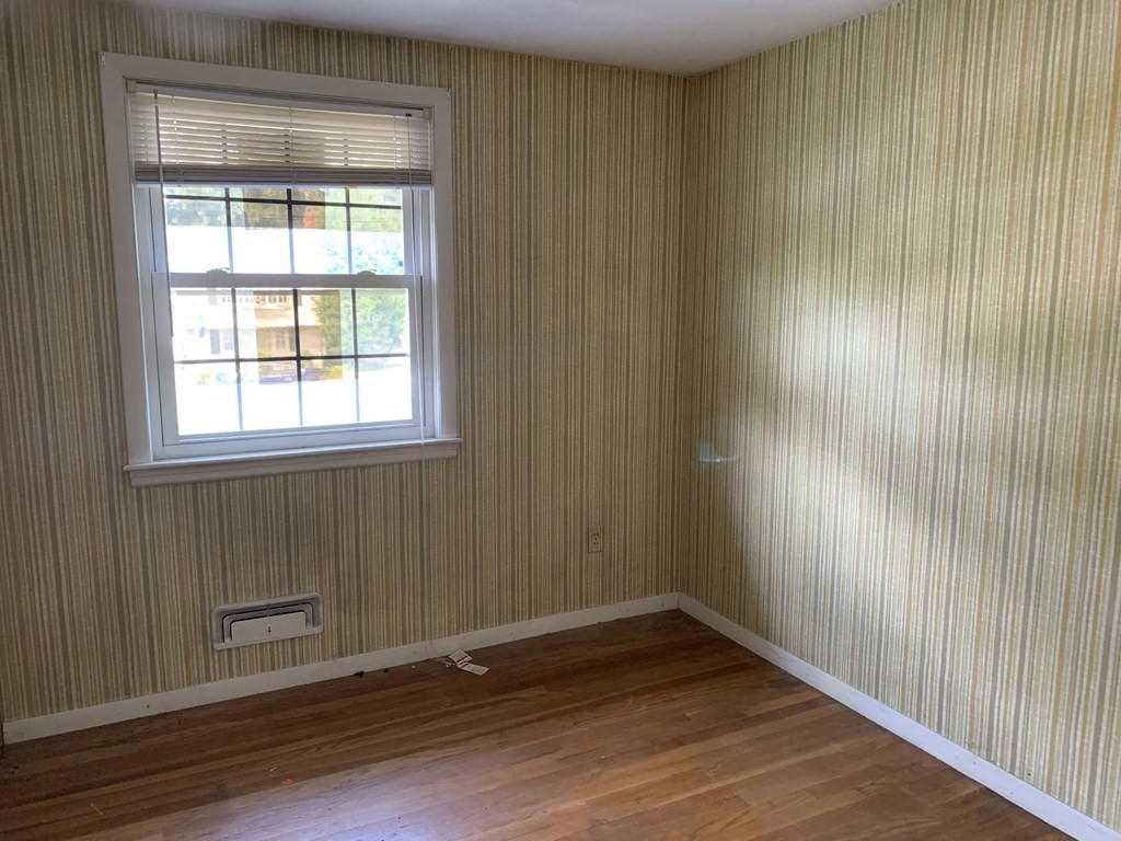 22 Redman Road Canton, MA 02021 - Photo 8 of 13 an empty room with wooden floor and windows with curtains